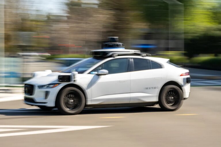 Waymo robotaxis on a city street equipped with lidar and camera sensors